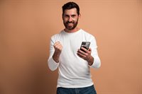 happy-satisfied-man-with-beard-holding-smartphone-and-smiling-making-yes-gesture-celebrating-online-lottery-or.jpg